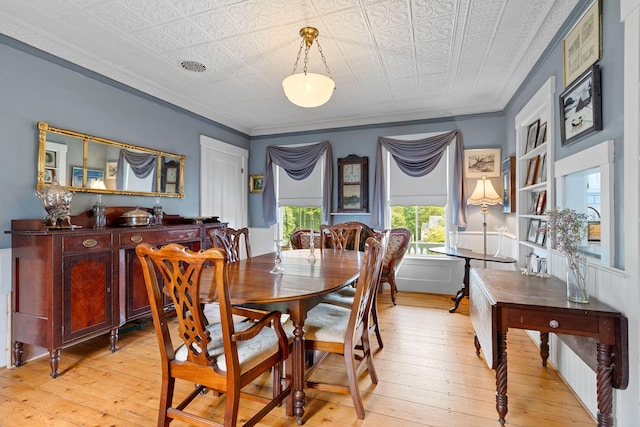 dining space featuring light hardwood / wood-style flooring and crown molding