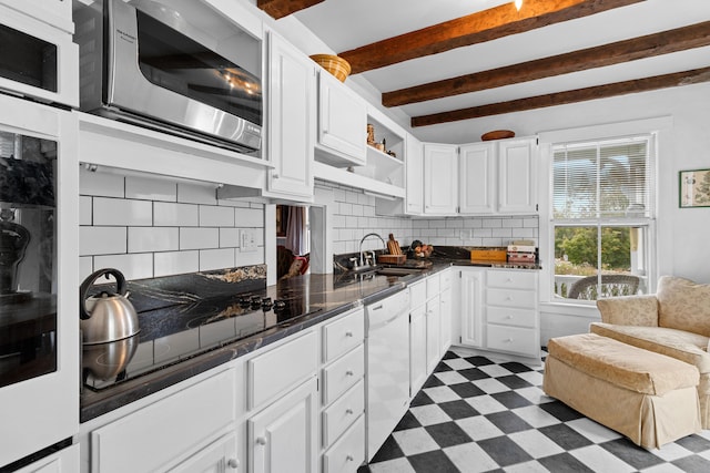 kitchen featuring dishwasher, stainless steel microwave, white cabinetry, and sink