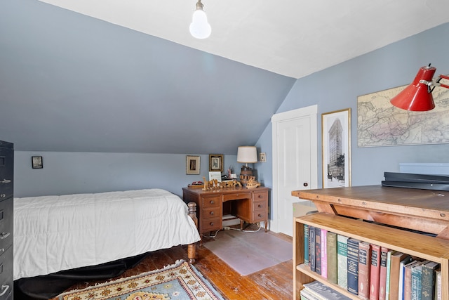 bedroom with vaulted ceiling and hardwood / wood-style floors