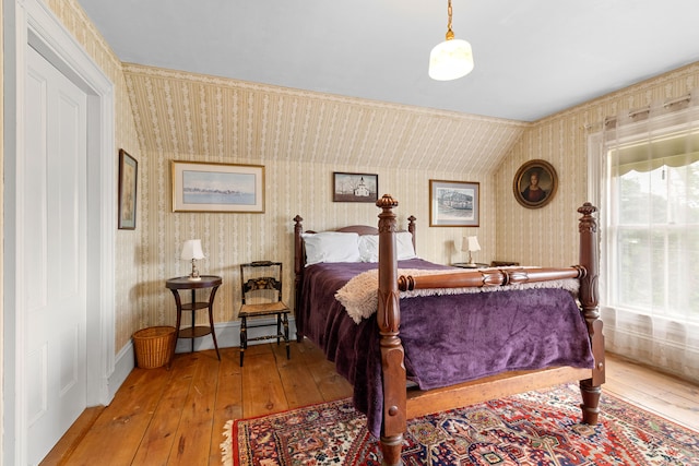 bedroom with vaulted ceiling and hardwood / wood-style floors