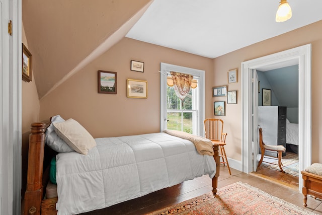 bedroom featuring vaulted ceiling and light hardwood / wood-style floors