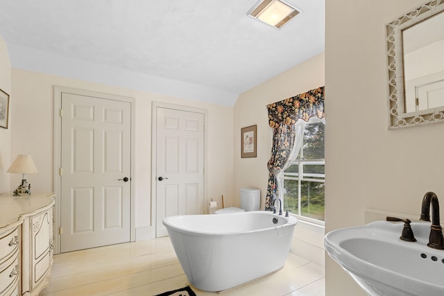 bathroom with vanity, a bathing tub, hardwood / wood-style floors, and toilet