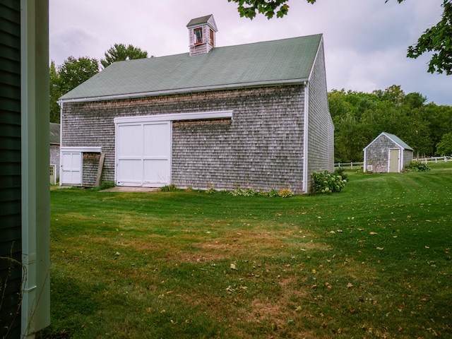 view of side of property featuring a shed and a yard