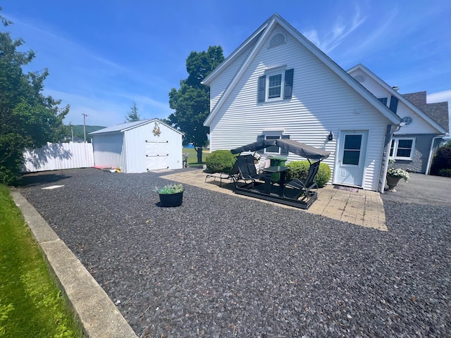 view of side of home featuring a patio, an outdoor structure, and a garage