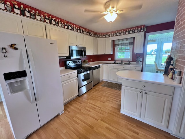 kitchen featuring ceiling fan, sink, white cabinetry, appliances with stainless steel finishes, and light wood-type flooring