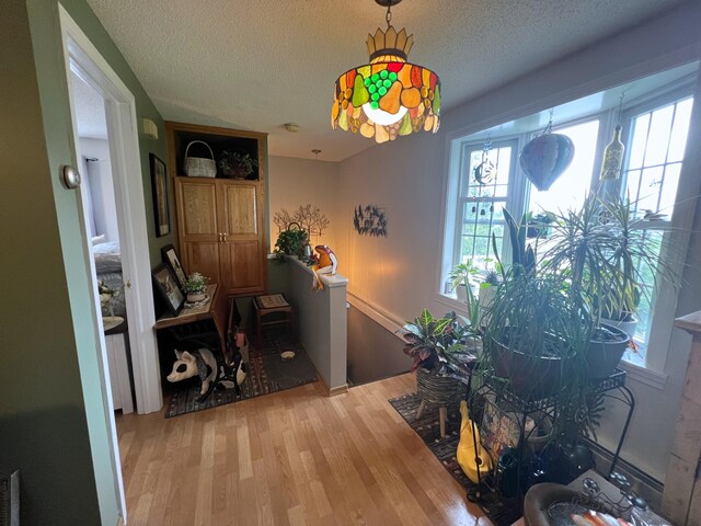 interior space featuring light wood-type flooring and a textured ceiling