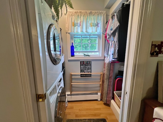 laundry room with stacked washer and dryer, light hardwood / wood-style floors, and baseboard heating