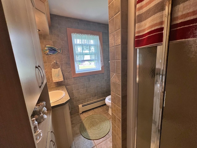 bathroom featuring vanity, toilet, a baseboard heating unit, and an enclosed shower