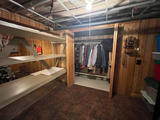 basement featuring wooden walls