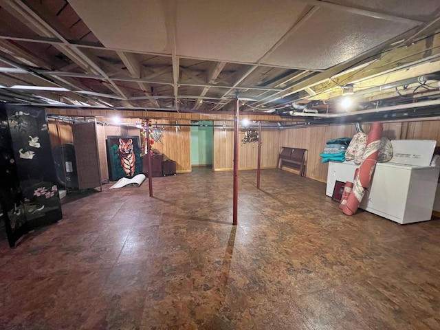 basement featuring wooden walls and washer / clothes dryer