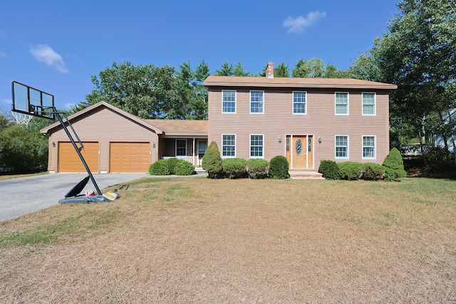 colonial house with a front lawn and a garage