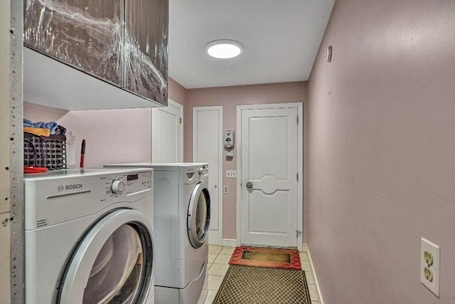 laundry area with light tile patterned floors, baseboards, washer and dryer, and laundry area