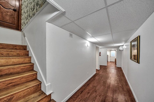 hallway featuring a paneled ceiling and hardwood / wood-style floors