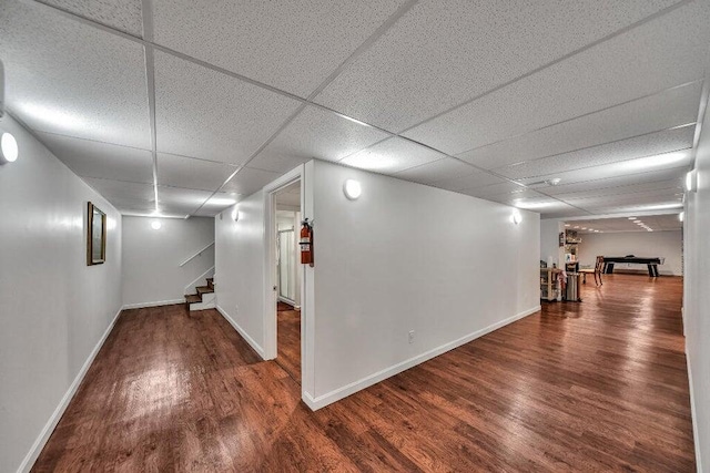 basement featuring a paneled ceiling and hardwood / wood-style floors