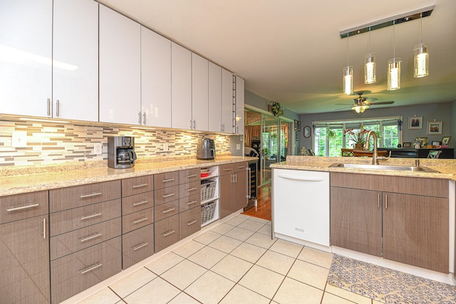 kitchen with white cabinets, white dishwasher, pendant lighting, light tile patterned floors, and sink