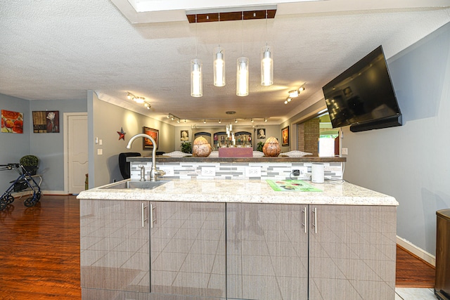 kitchen with a kitchen breakfast bar, sink, dark hardwood / wood-style floors, and a textured ceiling