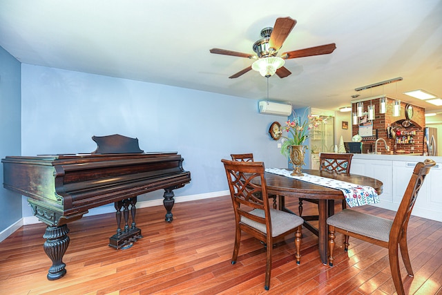 dining room with ceiling fan, light wood-type flooring, sink, and an AC wall unit