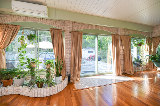 doorway to outside featuring brick wall, hardwood / wood-style floors, a wall mounted AC, and wooden ceiling