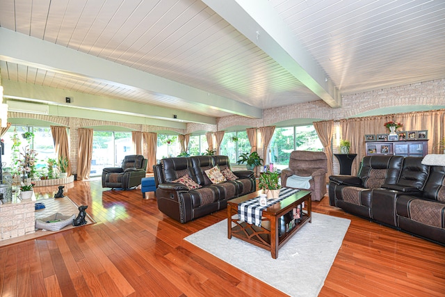 living room featuring wood-type flooring, beamed ceiling, and plenty of natural light