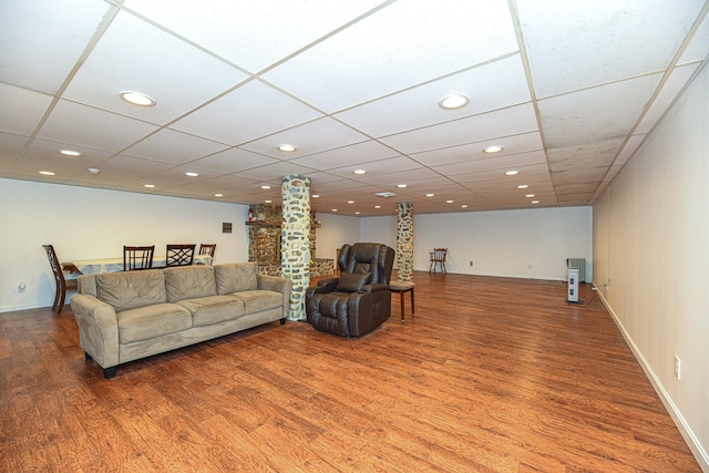 living room with wood-type flooring and a drop ceiling