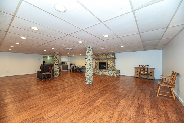 interior space featuring a drop ceiling, a fireplace, and wood-type flooring