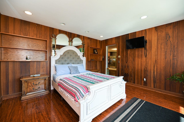 bedroom featuring dark wood-type flooring and wooden walls