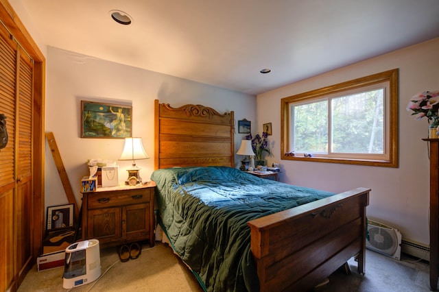 bedroom featuring a baseboard radiator, an AC wall unit, a closet, and light colored carpet