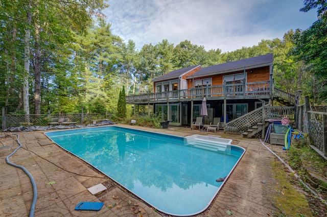 view of swimming pool with a wooden deck and a patio area