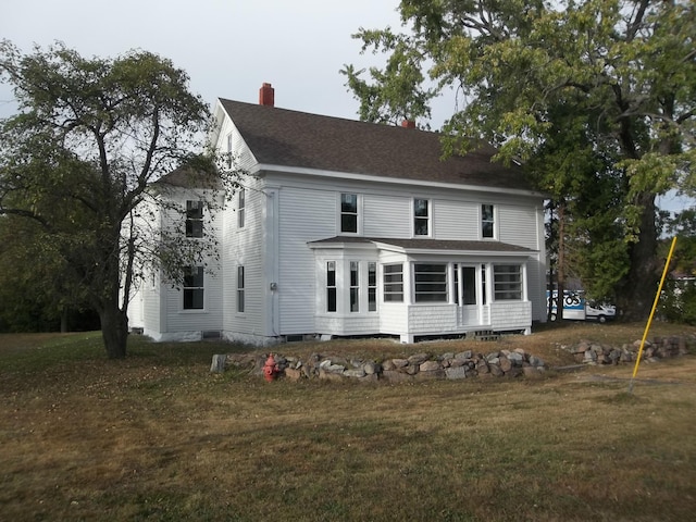 rear view of house featuring a lawn