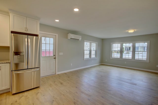 kitchen with white cabinetry, stainless steel refrigerator with ice dispenser, and a wealth of natural light