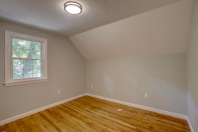 bonus room featuring light wood-type flooring and vaulted ceiling