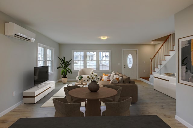 dining space with an AC wall unit and light hardwood / wood-style flooring