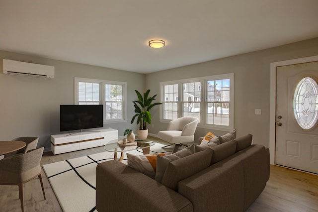 living room featuring light wood-type flooring, a wall unit AC, and a healthy amount of sunlight