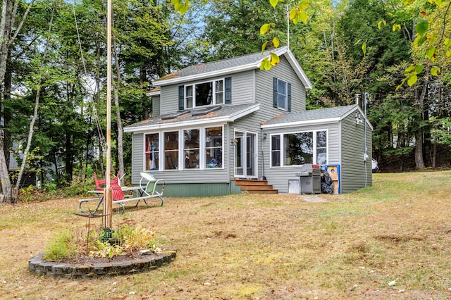 view of front of home with a front lawn and a sunroom