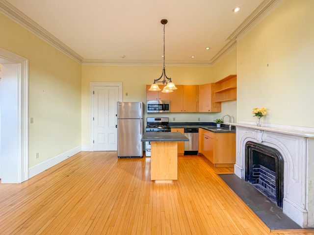 kitchen with light hardwood / wood-style flooring, sink, hanging light fixtures, appliances with stainless steel finishes, and ornamental molding