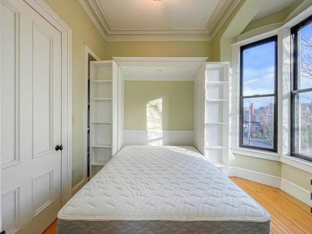 bedroom with ornamental molding and hardwood / wood-style flooring