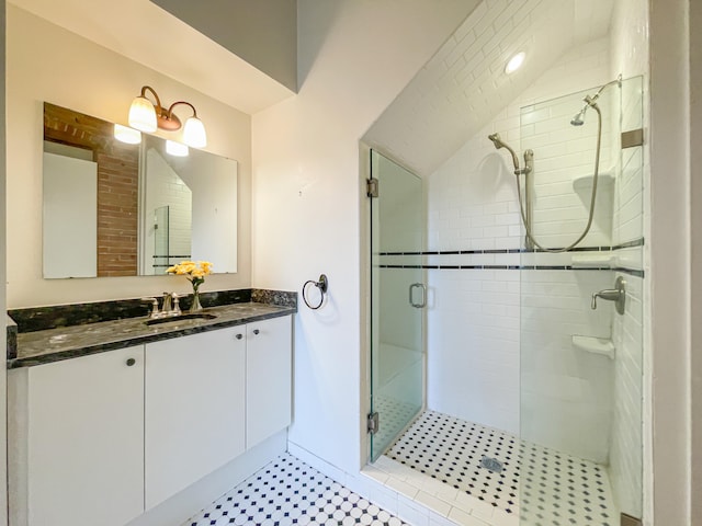 bathroom featuring a shower with door and vanity