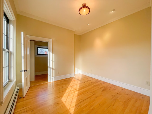 spare room featuring crown molding, light hardwood / wood-style flooring, and a baseboard radiator