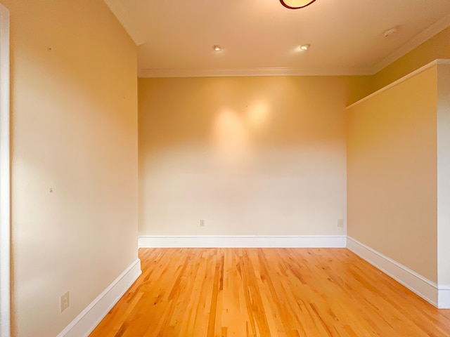 empty room featuring hardwood / wood-style flooring and crown molding