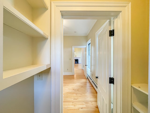 corridor featuring ornamental molding, light hardwood / wood-style flooring, and a baseboard radiator