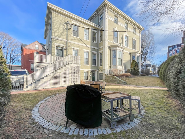 back of property with a patio area, a lawn, and a deck