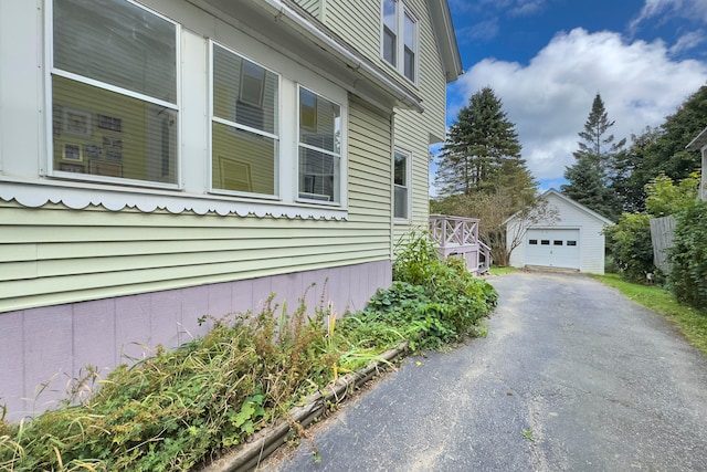 view of property exterior with an outdoor structure and a garage