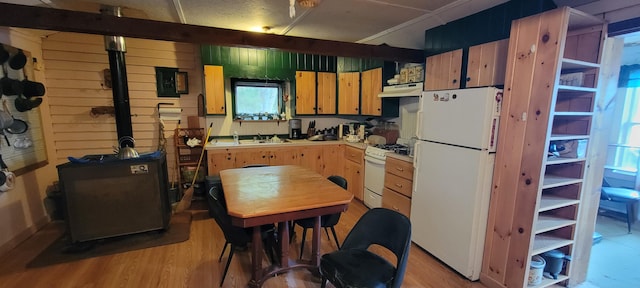 kitchen with wooden walls, white appliances, and light wood-type flooring