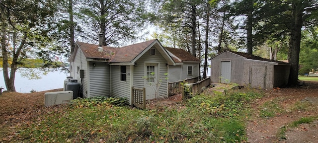 exterior space featuring a storage shed and a water view