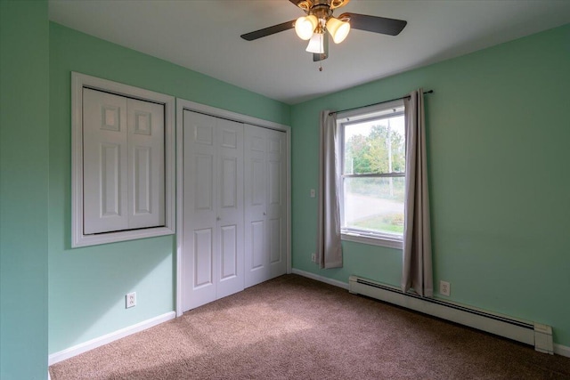 unfurnished bedroom featuring two closets, ceiling fan, light colored carpet, and a baseboard radiator