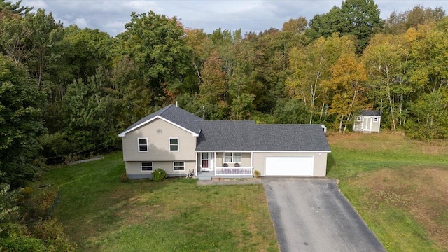 view of front facade featuring a garage, a front lawn, and covered porch