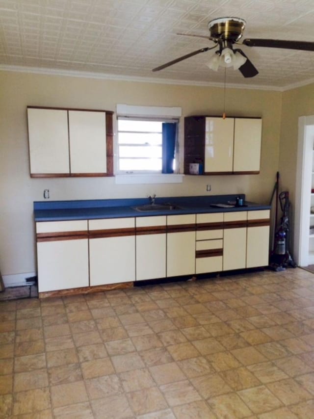 kitchen with a sink, a ceiling fan, white cabinets, and dark countertops