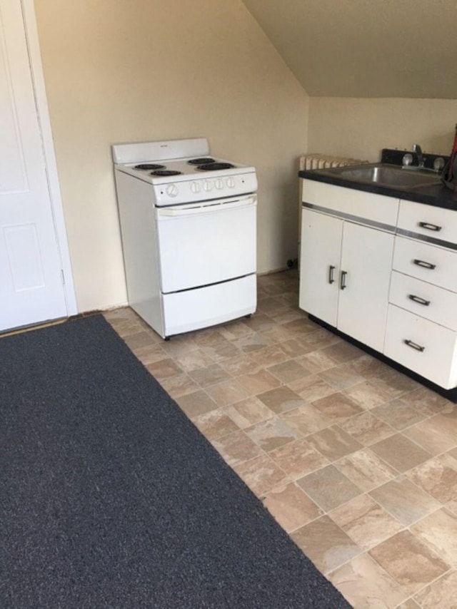 kitchen with a sink, dark countertops, white cabinets, and white range with electric cooktop