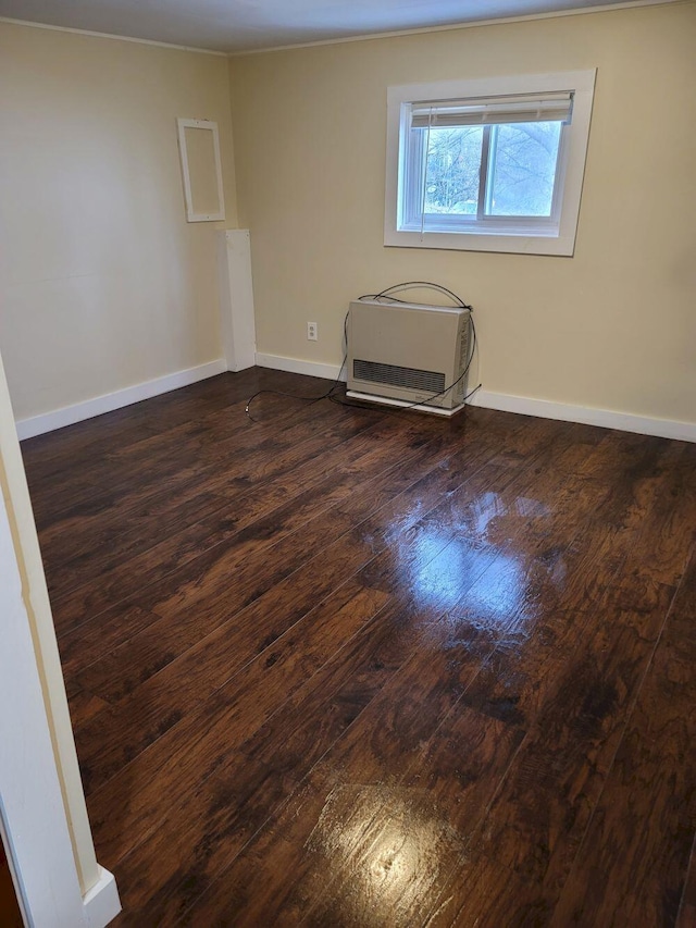 spare room with baseboards and dark wood-style floors