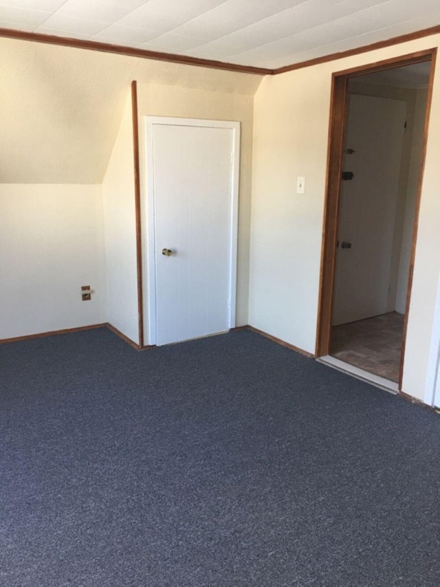unfurnished bedroom featuring carpet floors, baseboards, and crown molding